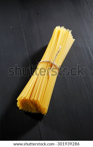 Raw pasta on black table close-up