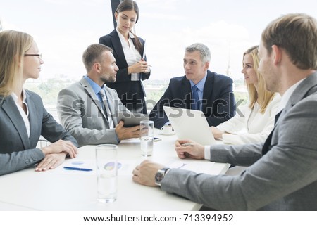 Meeting of business partners using laptops and talking at the table