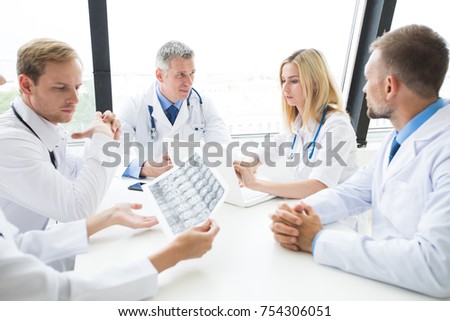 Clinic, people, healthcare and medicine concept - group of medics with brain x-ray scan at hospital