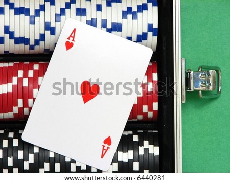 A close up on an ace card over poker chips arranged inside a carrying case. Three rows with white, red and black chips.