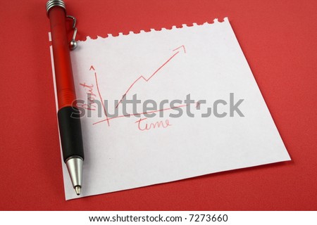 A red pen and a hand draw graph on a notepad over a red surface