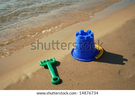 bucket beach toy on the sand near the water