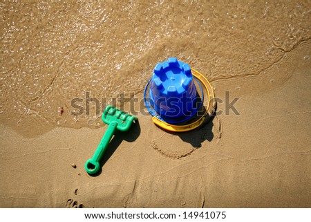 top view of beach toys in the sand near the water