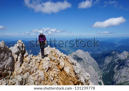Mountaineer woman on top of a mountain on a beautiful day