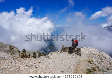 Man sitting on a bench and enjoying the view in the mountains, Greece, Mount Olympus.