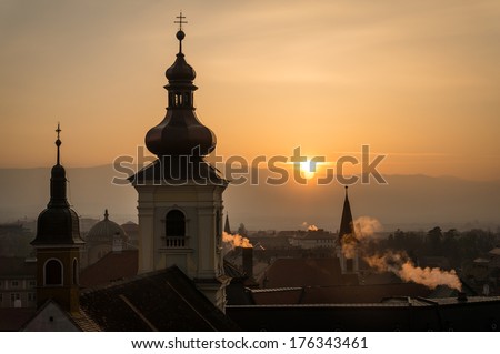 Sunset view of Sibiu city with smoking chimney, Romania