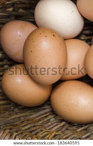 Antique basket of organic, natural, farm-fresh eggs on old board. Vertical shot. Closeup.