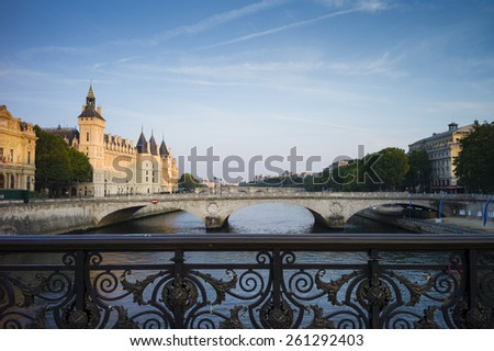 River Seine Paris, France in early morning light, with Conciergerie and bridge. Ornate handrail in the foreground.