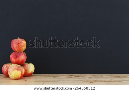 Panel surface, with five apples on the tray made of wood. Panel surface in black.