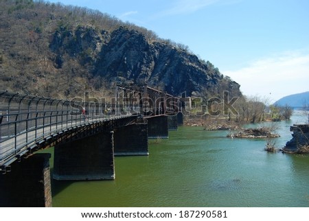 HARPERS FERRY, WV -  APRIL 14, 2014: People crossing the bridge on the Appalachian Trail where the Potomac River meets the Shenandoah River.