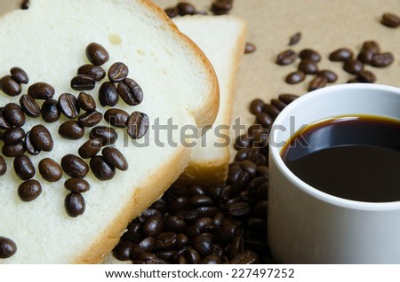 cup of coffee ,coffee beans , rich and soft sliced bread