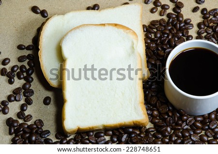 cup of coffee ,coffee beans , rich and soft sliced bread