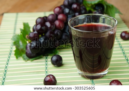 grapes juice and fruit on wooden background. Healthy drink