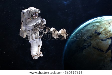 Astronaut in outer space against the backdrop of the planet. Elements of this image furnished by NASA.