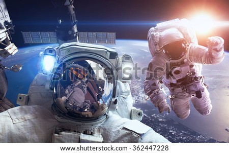 International Space Station with astronauts over the planet Earth. Elements of this image furnished by NASA