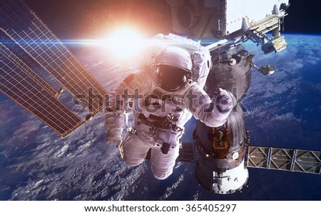 International Space Station with astronauts over the planet Earth. Elements of this image furnished by NASA
