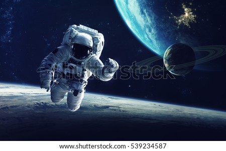 Astronaut at spacewalk. Cosmic art, science fiction wallpaper. Beauty of deep space. Billions of galaxies in the universe. Elements of this image furnished by NASA