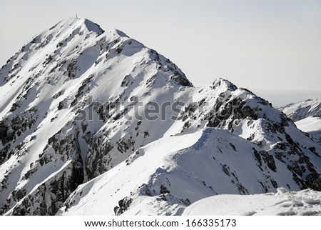 Snowed mountain ridge with mountain summit in background