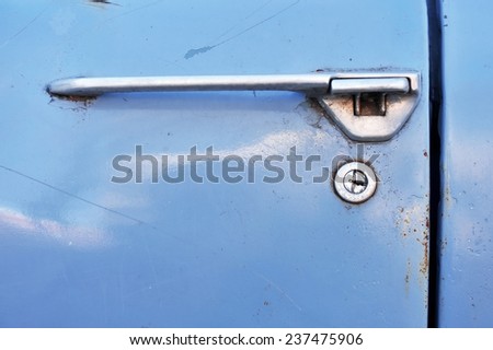 Close up shot with an old and rusty car door lock