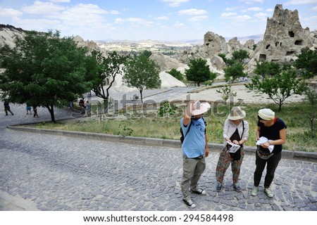 CAPPADOCIA/TURKEY - JUNE 26: Tourists looking at guide books in the Rose Valley ancient site on June 26, 2014 in Cappadocia.