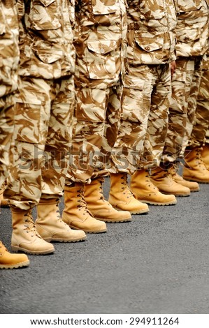 Soldiers feet in desert camouflage military uniform in rest position