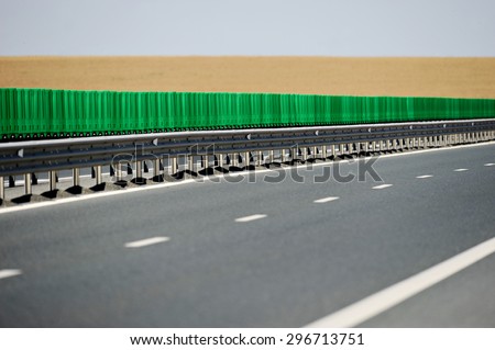 Empty two lane highway with wheat field on the background