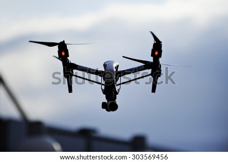 BUCHAREST/ROMANIA - AUGUST 1: Aerial filming drone in action, silhouetted against blue sky, on August 1, 2015 in Bucharest.