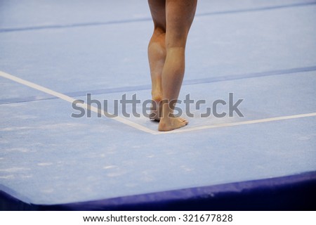 Feet of gymnast are seen on the floor exercise during gymnastics competition
