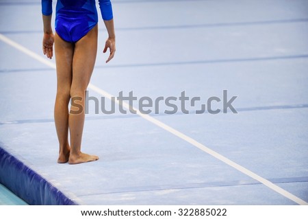 Feet of gymnast are seen on the floor exercise before gymnastics competition