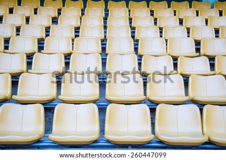 Many  Yellow Stadium seats on blue floor