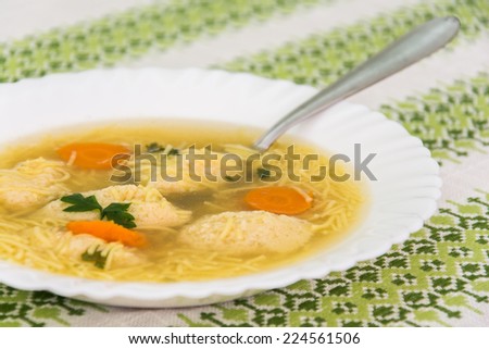 A plate of homemade soup with dumplings and noodles