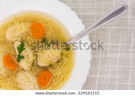A plate of homemade soup with dumplings and noodles