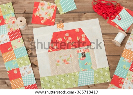 Quilted House. Sewing And Quilting Accessories. Fabric Patches. Wooden Table.
