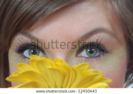closeup picture of woman eyes behind yellow flower