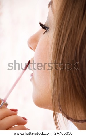 nice girl painted own\'s lips by shine. shallow DOF