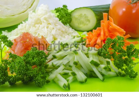 Finely chop cabbage, tomatoes, cucumbers and carrots for salad