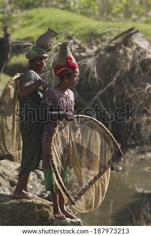 Bardia Nepal - November 11, 2013: Two nepali Taru women wear traditionnal hat and nest used for river fishing.