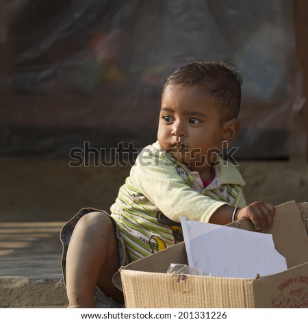 Bardia, Nepal - November 25, 2013 : Unidentified young nepali boy portrait play with a carton box in Bardia, Nepal, 2013