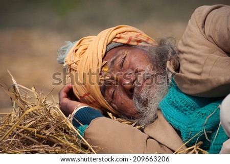 Bardia, Nepal - January 15, 2014: Portrait of very old poor taru man sleeping in Bardia, Nepal