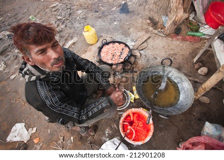 Bardia, Nepal - January 16, 2014: Nepali man cook pastries during Maggy festival fair, in Bardia, Nepal