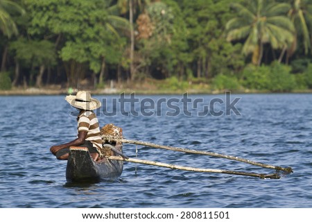 Traditional fisherman in dugout canoe in Sri Lanka