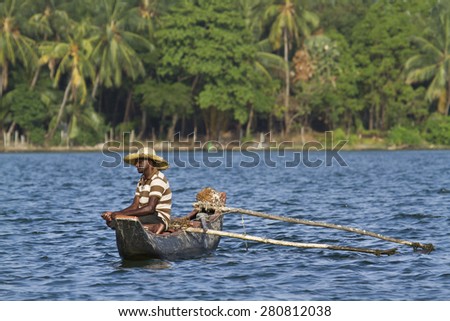 Batticalao, Sri Lanka - June 22, 2014: Traditional fisherman in dugout canoe in Sri Lanka. In Sri Lanka coast, poor people try to fish for they daily food