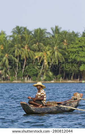Batticalao, Sri Lanka - June 22, 2014: Traditional fisherman in dugout canoe in Sri Lanka. In Sri Lanka coast, poor people try to fish for they daily food