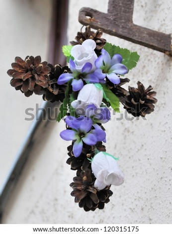 Christian Easter Cross with flowers and pine cones on the wall