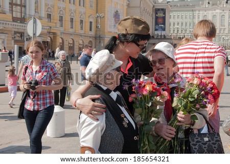 Young girl congratulates older women veterans of the Great Patriotic War on holiday near the Bolshoi Theater in Moscow on May 9, 2013