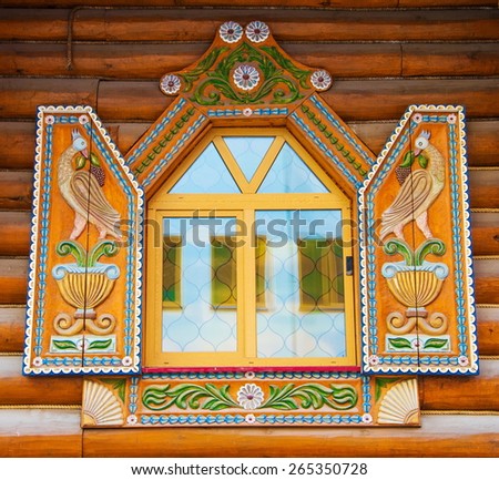 Window of an old log house with shutters decorated with wood carvings