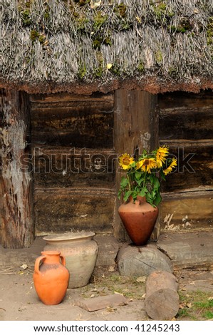 Fragment of the old wooden house. Sunflowers in the vase.