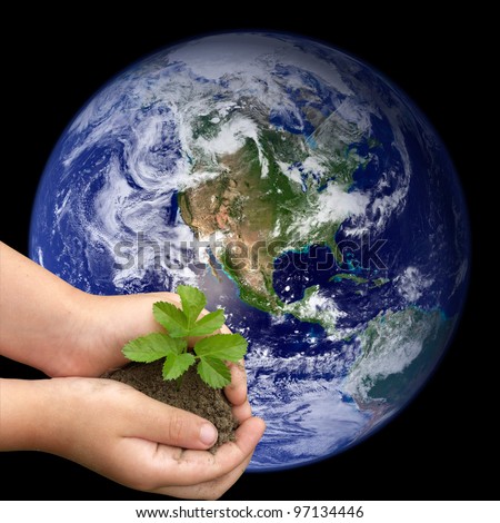 Children\'s hands holding small plant growing from soil on the background of the world. Elements of this image furnished by NASA