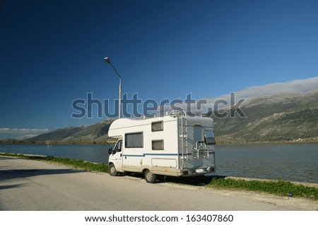 car caravan lake and mountains sunny day