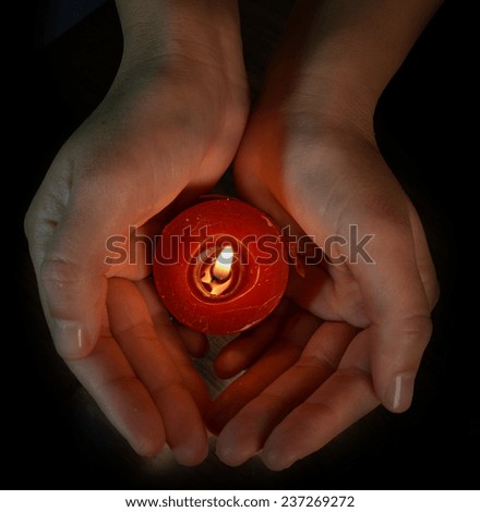 red candle in the night - religion xmas easter - closed hands
